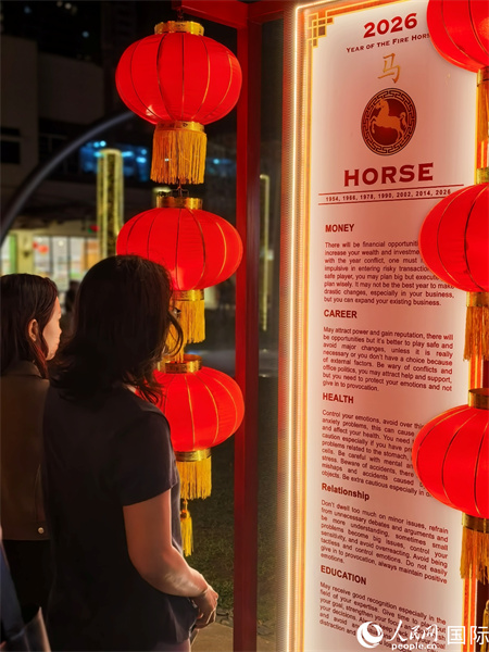 在菲律宾最繁华的博尼法乔环球中心商业区步行街,菲律宾民众在介绍十二生肖等春节习俗的展牌前驻足观看。人民网记者樊帆 摄