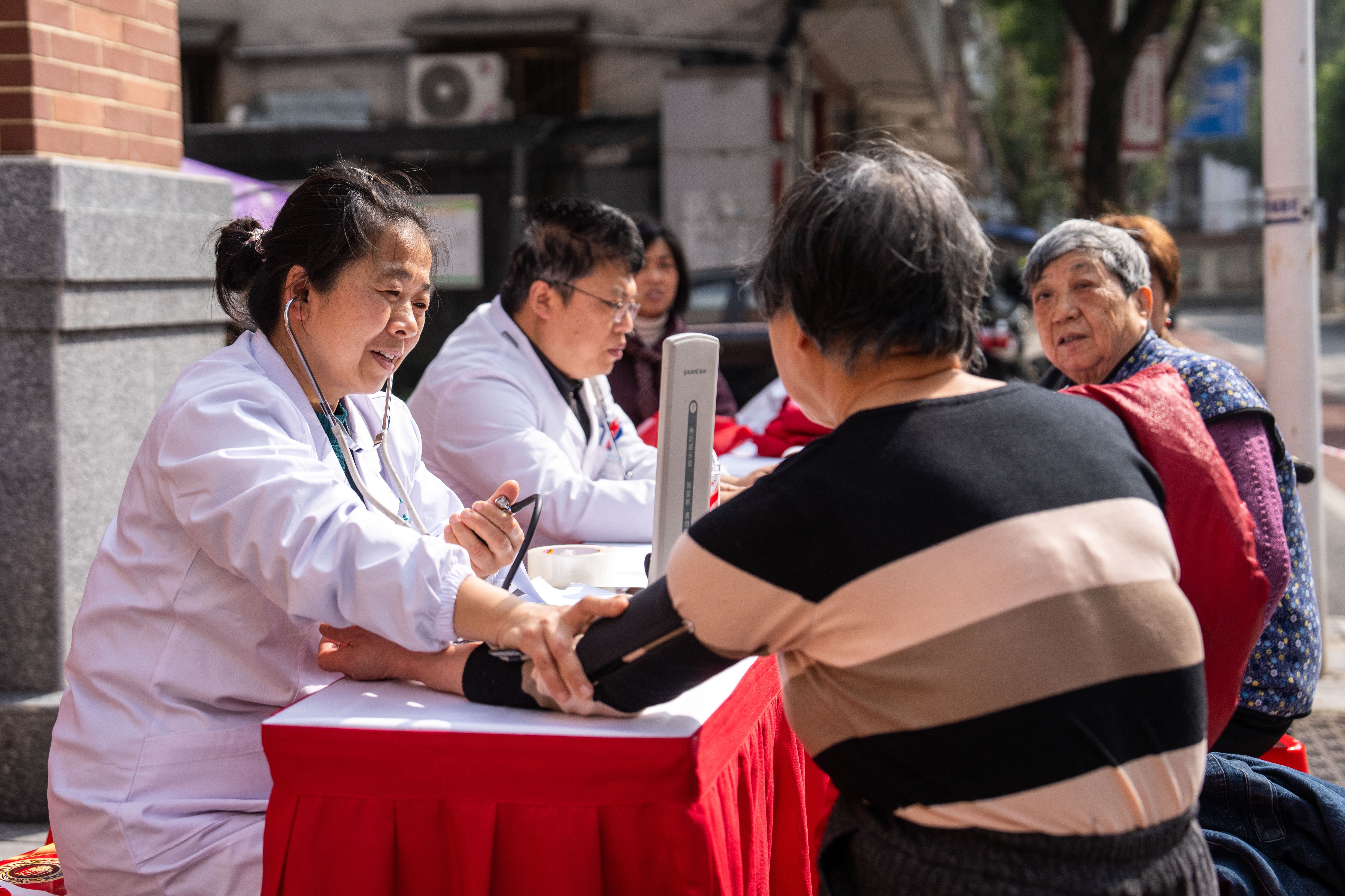 2026年3月5日,在湖南长沙市望城区高塘岭街道雷锋路社区雷锋驿站,志愿者(左一)为市民测量血压。新华社记者 陈思汗 摄