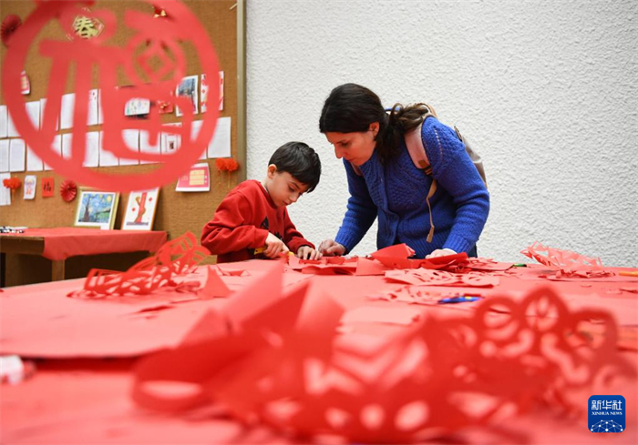 2月9日，在瑞士日内瓦，日内瓦中文学校的学生在2025蛇年春节联欢会上体验剪纸。 新华社记者 连漪 摄