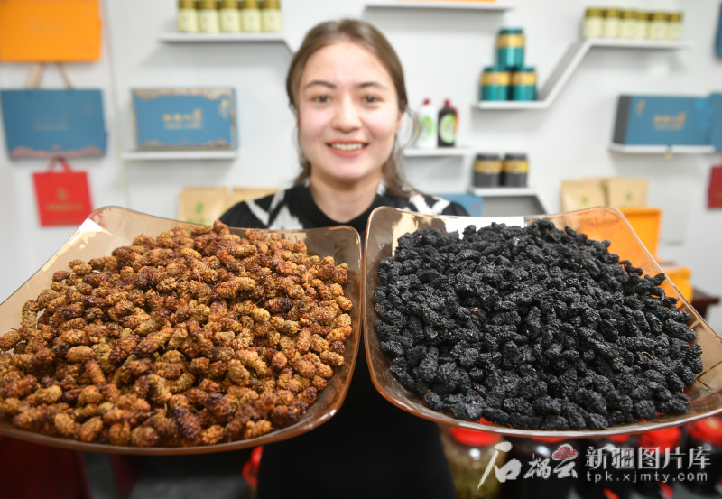 工作人员在阿克陶县陶桑缘桑果深加工有限公司展示经过生产加工的桑葚。